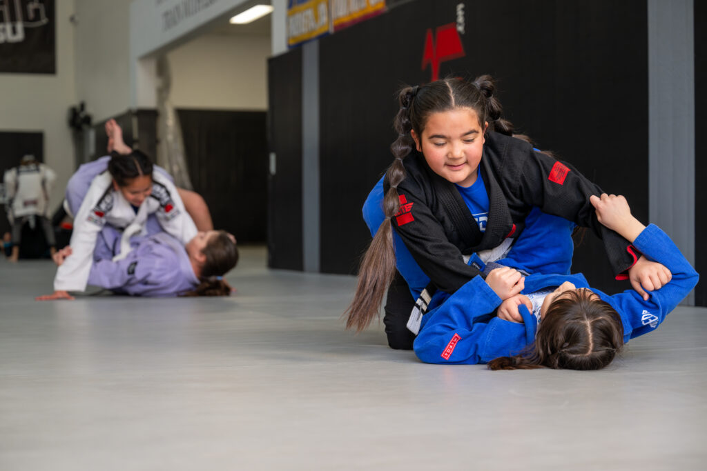 Young student training in a blue gi on the academy mats